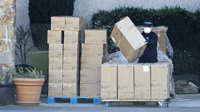 A worker at the Life Care Center in Kirkland, Wash., wears a mask as he stacks newly arrived boxes.