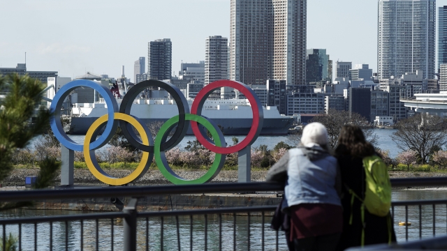 Tourists look at the Olympic rings at Tokyo's Odaiba district.