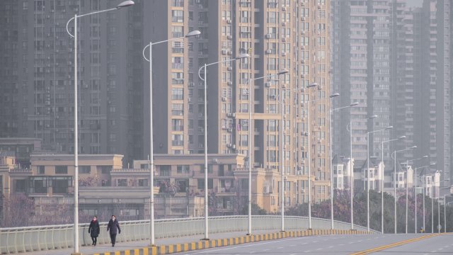 People walking on an empty street in Wuhan