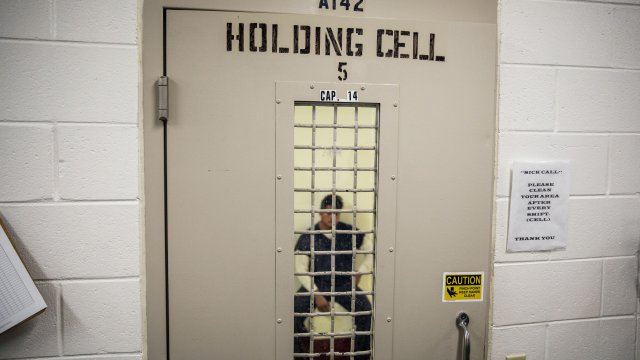 An ICE detainee sits in a holding cell