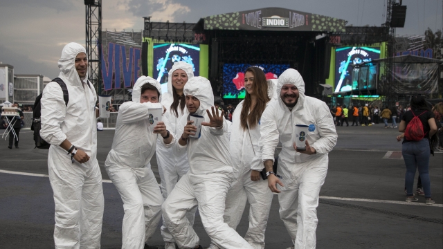 Fans pose in bio suits at March 14 Vive Latino music festival in Mexico, where the president has downplayed the coronavirus.