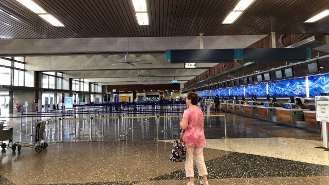 Woman stands at airport in Hawaii