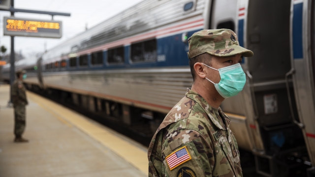 Members of the Rhode Island National Guard look for passengers getting off from a train from New York as it arrives Saturday
