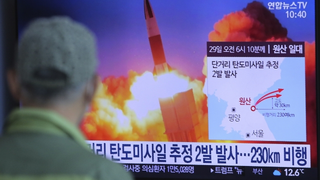A man watches a TV screen showing a file image of North Korea's missile launch during a news program
