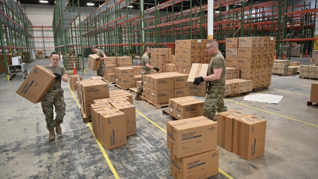 National Guard members move boxes of supplies