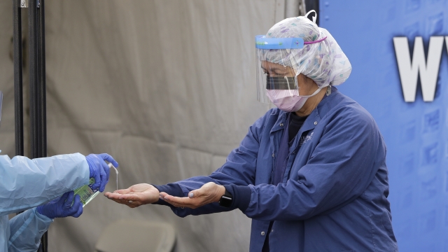 A registered nurse, has hand sanitizer applied on her hands after removing her gloves.