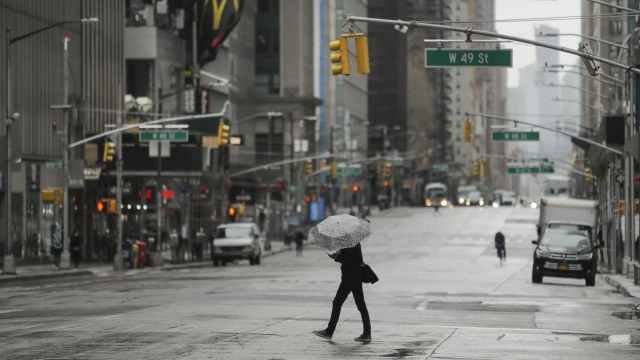 A pedestrians crosses a mostly empty Sixth Avenue during the coronavirus outbreak