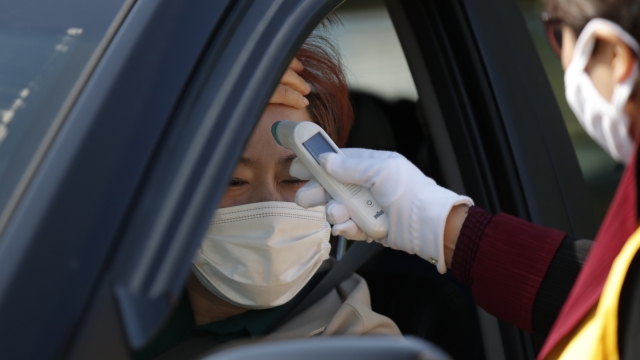 Woman in Seoul has temperature checked at drive-in church service