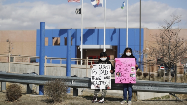 Protesters hold placards outside an ICE detention center