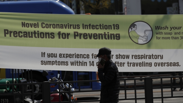A man walks near a banner showing precautions against the new coronavirus at a park in Seoul, South Korea, Thursday, April 9