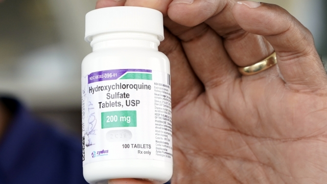 A doctor holds a bottle of hydroxychloroquine while posing outside a nursing home in Texas City, Texas on April 7, 2020.