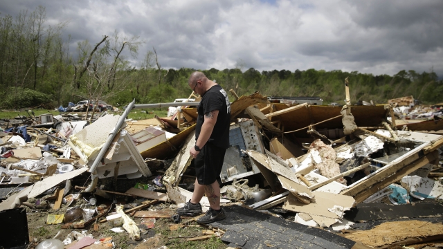 Aaron Pais kicks around debris at a mobile home park after a tornado hit on Monday, April 13, 2020, in Chatsworth, Ga.