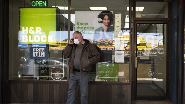 Man in mask outside H&R Block storefront