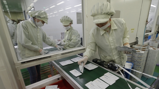 Employees work on a production line of the ichroma COVID-19 Ab testing kit used in diagnosing the coronavirus
