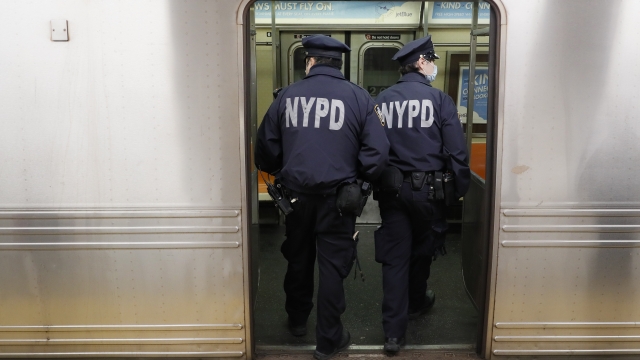 NYPD officers wake up sleeping passengers and direct them to the exits at the 207th Street A-train station, Thursday, April 3