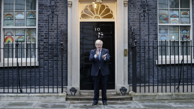 Britain's Prime Minister Boris Johnson applauds on the doorstep of 10 Downing Street in London