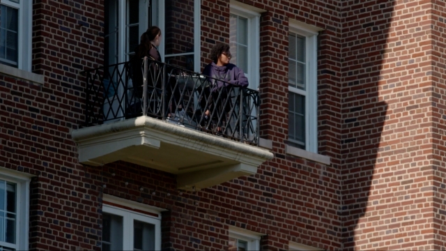 Two people on a balcony.