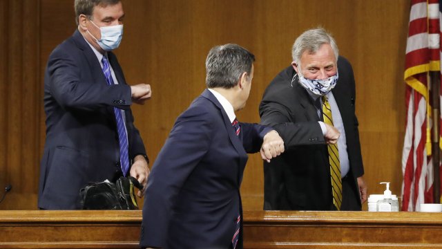 DNI nominee Rep. John Ratcliffe elbow bumps the Chairman and Ranking Member of the Senate Intelligence Committee.