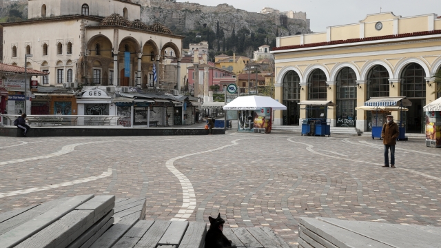A solitary man and a stray cat in Athens' normally crowded Monastiraki Square.