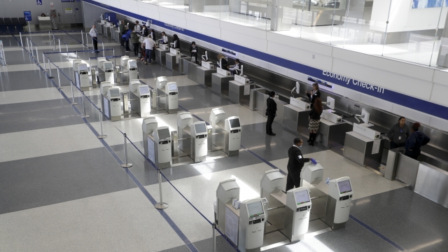 Sparse crowds make their way to a check-in counter at the United terminal at Los Angeles International Airport
