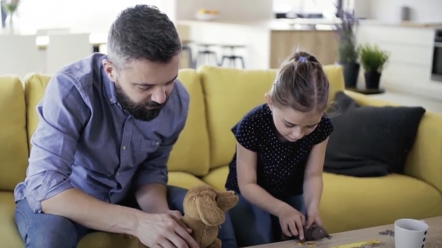 Father and daughter building puzzle