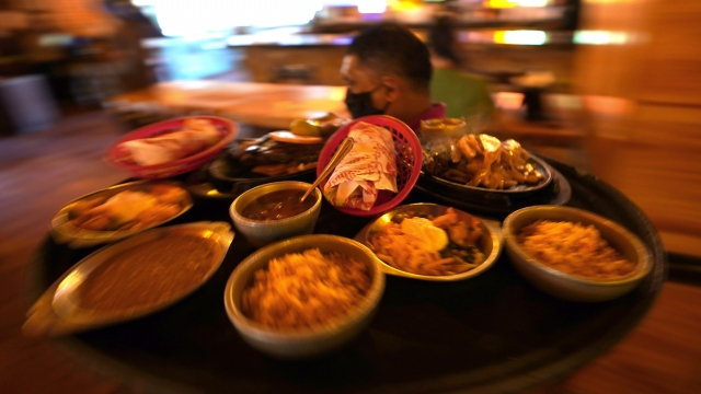 Adolfo Rojas carries a tray of food for dine-in customers at El Tiempo Cantina Friday, May 1, 2020, in Houston