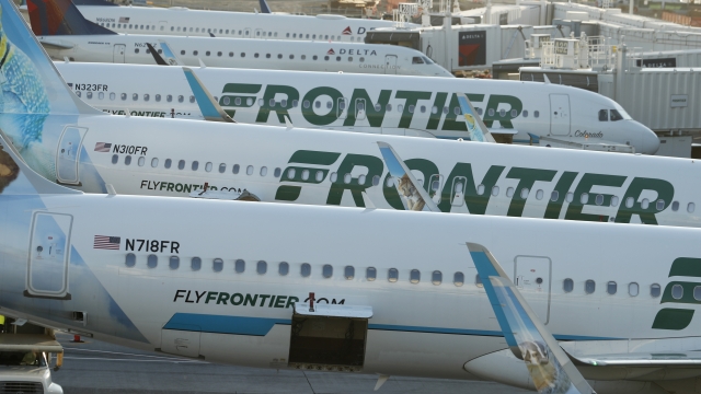 Frontier Airlines jetliners sit at gates on the A concourse at Denver International Airport in Denver