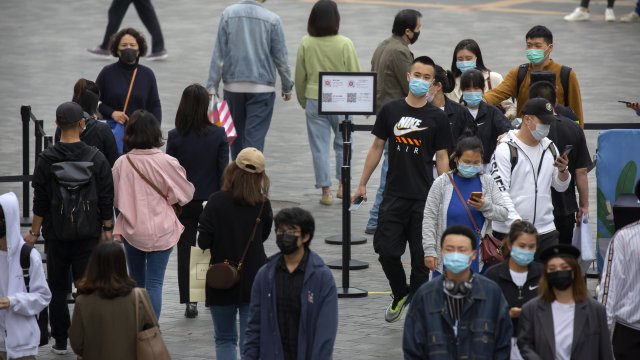 People wearing face masks at an outdoor shopping center in Asia