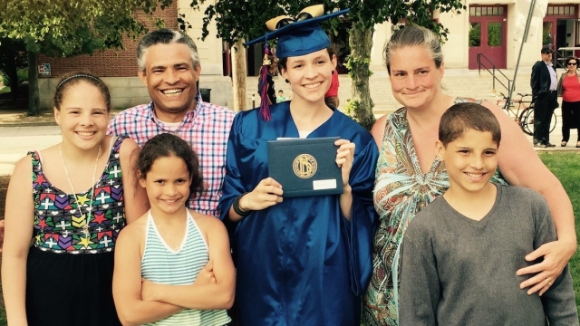 First-generation college graduate Karina Da Rosa poses with family at her graduation