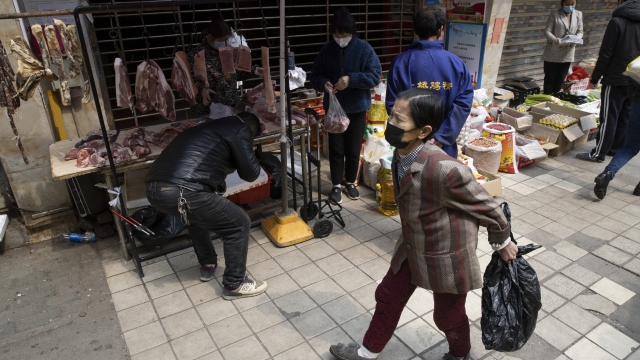 Residents walk past stalls near a partially closed off market due to the coronavirus outbreak in Wuhan