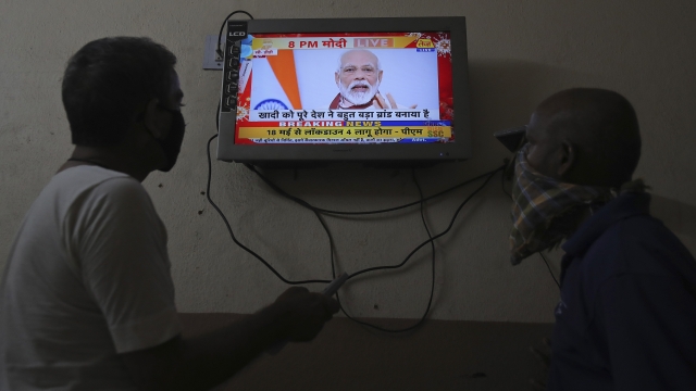 Indians watch a televised address to the nation by Prime Minister Narendra Modi in Hyderabad, India, Tuesday, May 12, 2020