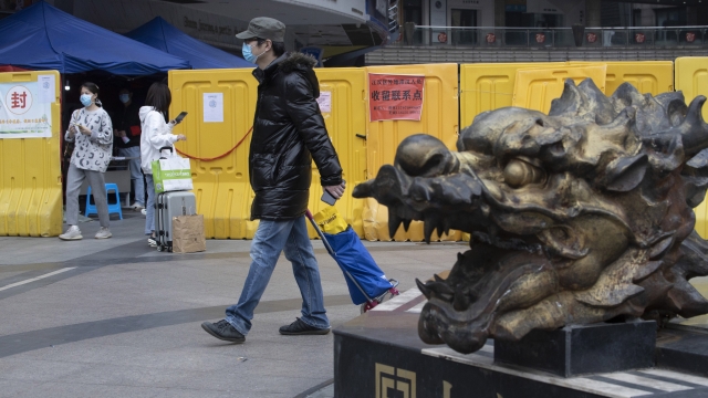 Residents walk near sealed off neighborhood in Wuhan, China on April 5.