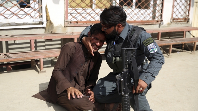 Afghan soldier consoles man after gunmen attacked a hospital in Kabul on Tuesday.