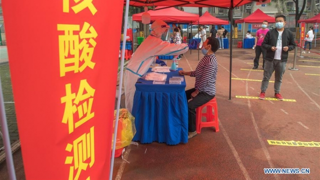 Residents take nucleic acid tests at a testing post set up at a primary school in Dongxihu District in Wuhan