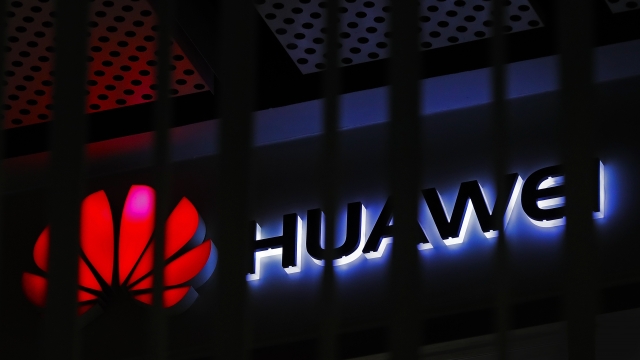 A logo of Huawei retail shop is seen through a handrail inside a commercial office building in Beijing