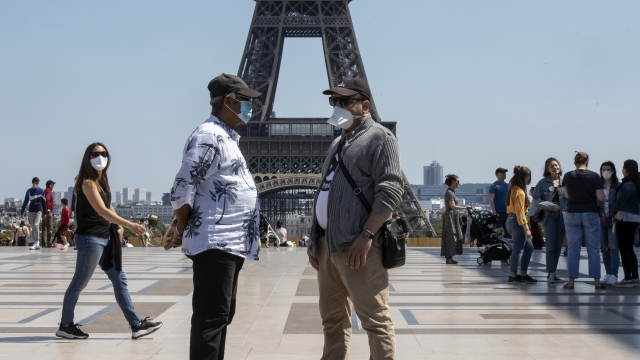People wear a faces as they stroll at Trocadero square next to the Eiffel Tower in Paris
