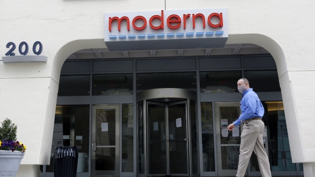 A man stands outside an entrance to a Moderna, Inc., building