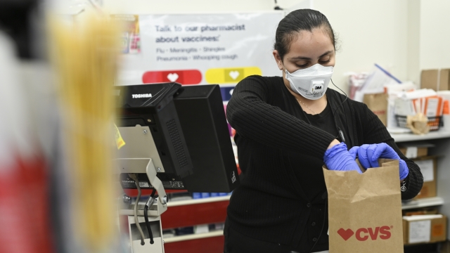 A CVS Pharmacy employee bagging a purchase