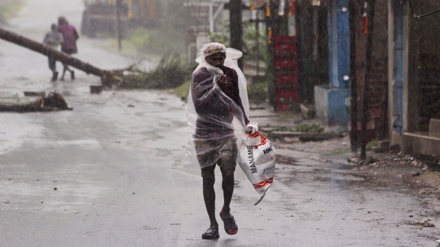 Man walks in the rain ahead of Cyclone Amphan landfall