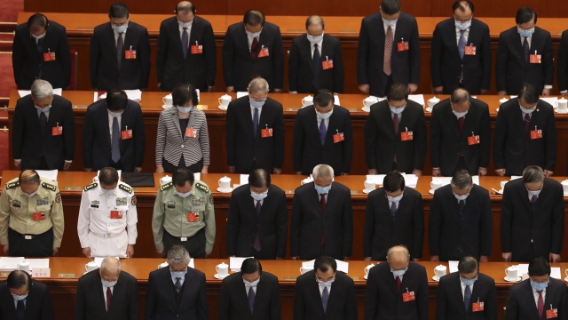 Delegates bow their heads during the opening session of China's National People's Congress