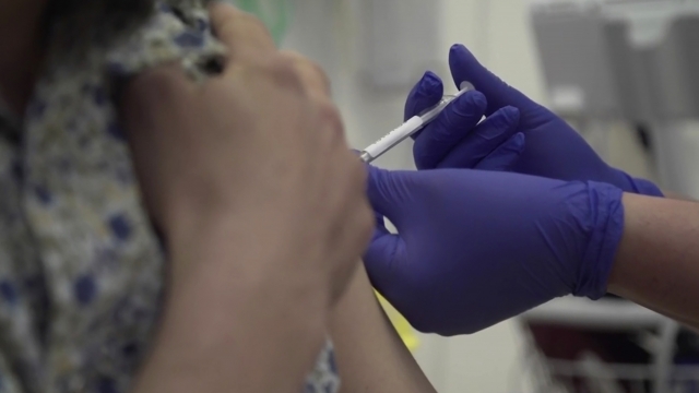 A person is injected with a vaccine as part of the first human trials in the UK to test a potential vaccine
