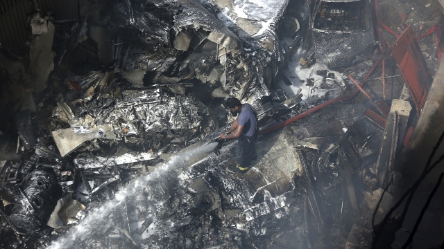 A firefighter tries to put out fire caused by plane crash in Karachi, Pakistan, Friday, May 22, 2020.