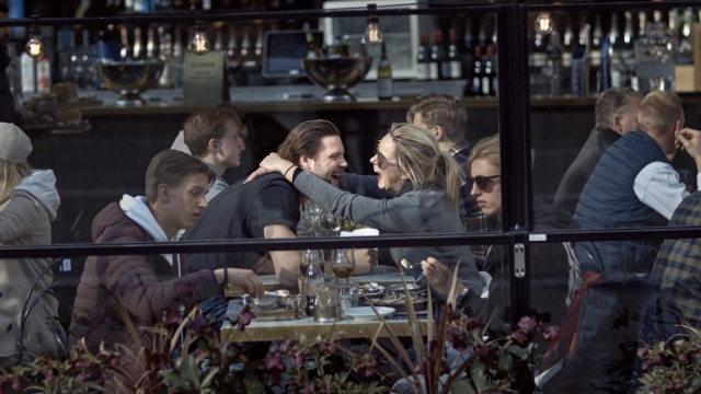 A couple hug and laugh as they have lunch in a restaurant in Stockholm, Sweden on April 4, 2020.