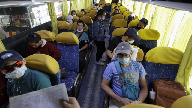 Overseas Filipino workers, who got quarantined as they arrived in the country weeks ago, wait inside a bus.