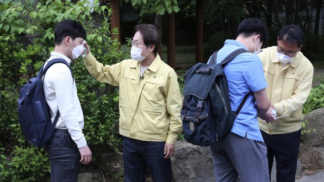 South Korean students receive a body temperature check on Wednesday, May 20, 2020