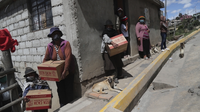 Residents near Andean city of Quito, Ecuador, gather government-distributed food boxes.