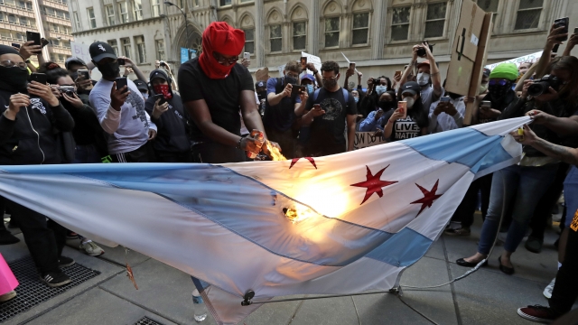A protester burns the Chicago flag