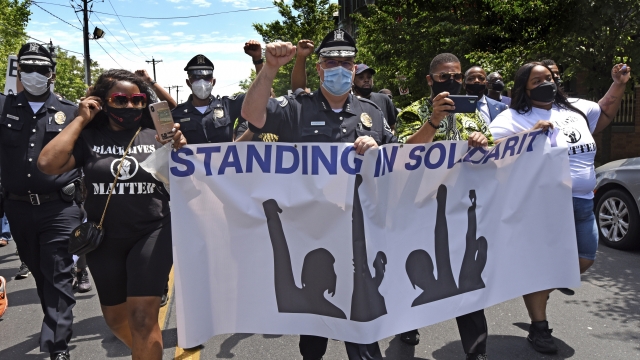 Camden County Metro Police Chief Joe Wysocki raises a fist while marching with residents and activists in Camden, N.J.