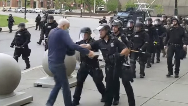 In this image from video provided by WBFO, a Buffalo police officer appears to shove a man who walked up to police