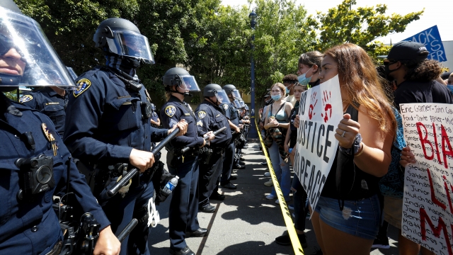 Protesters face the San Diego Police Department